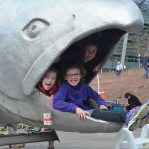 Kids play in fish mouth statue